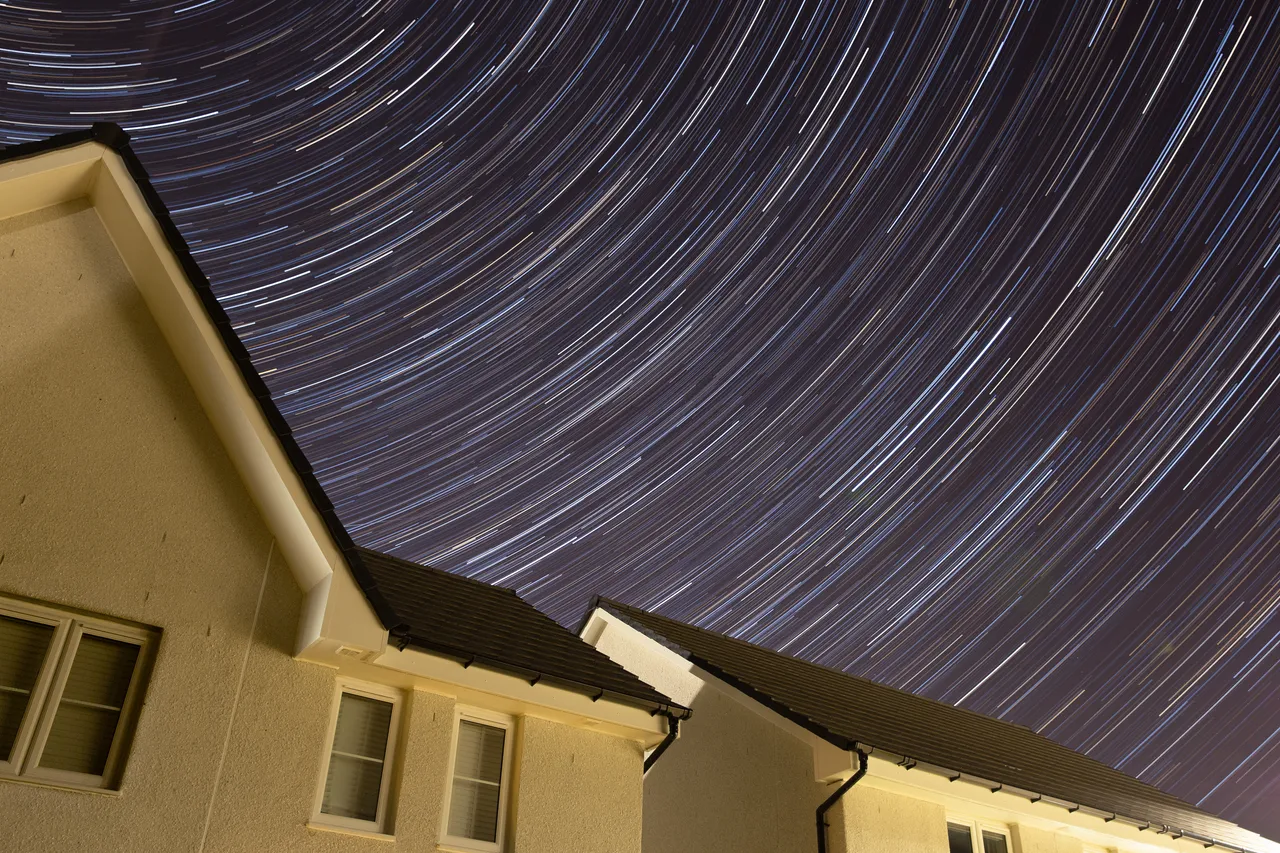 Star trails over suburban rooftops