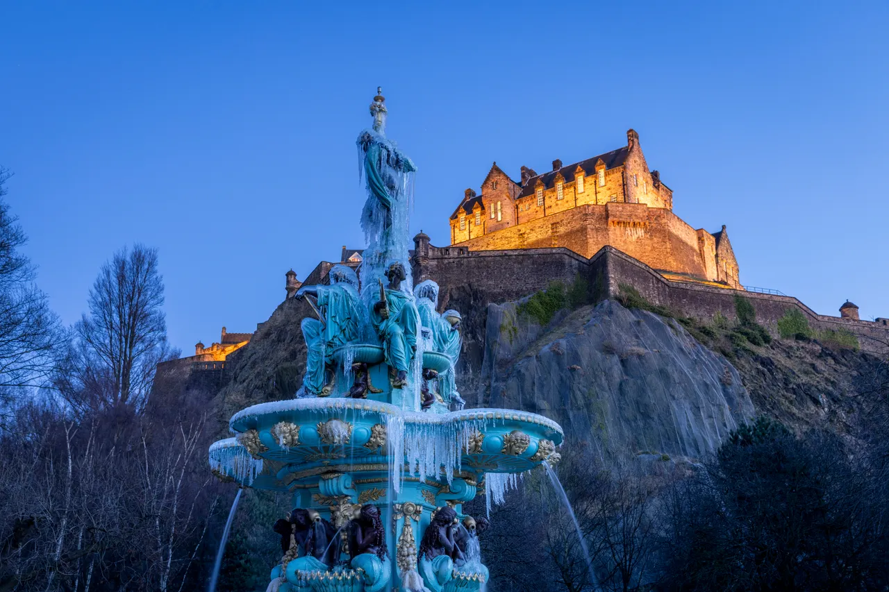 A frozen Ross Fountain with Edinburgh Castle from Princes Street Gardens