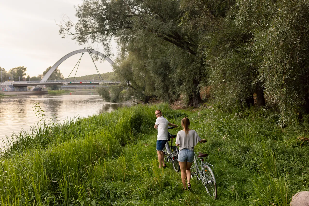 Man and woman walking next to river