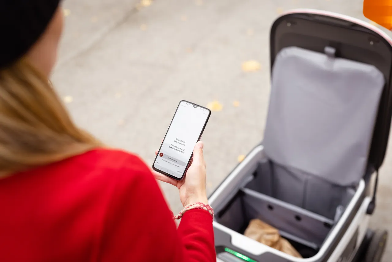 Women receiving Starship delivery robot order