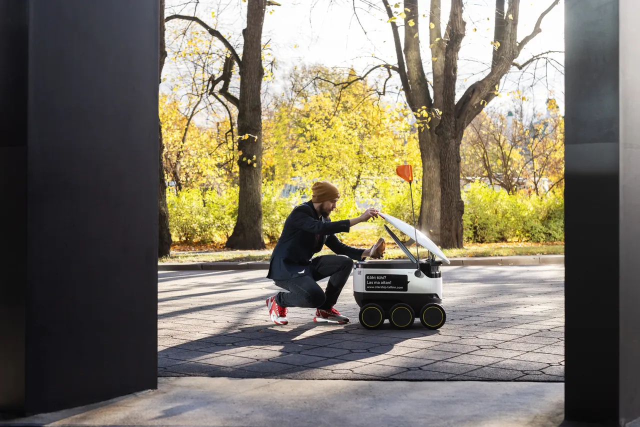 Man taking package from Starship delivery robot
