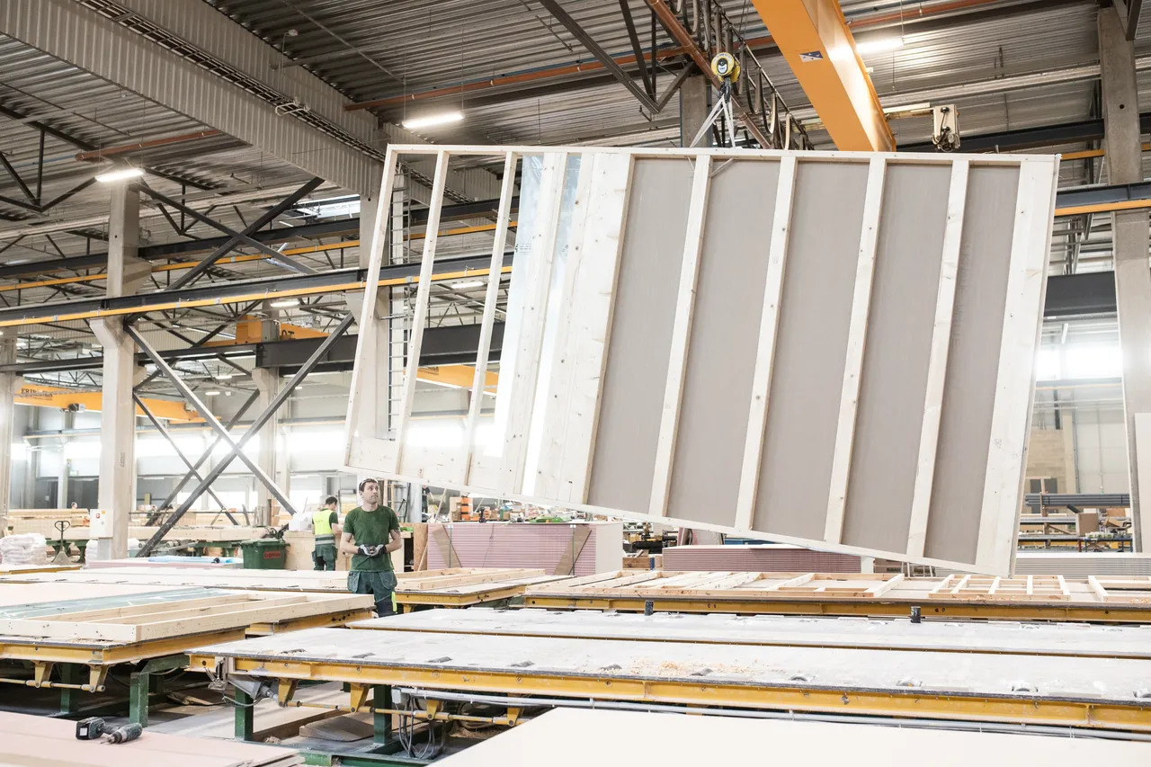 Man lifting wooden modular house elements