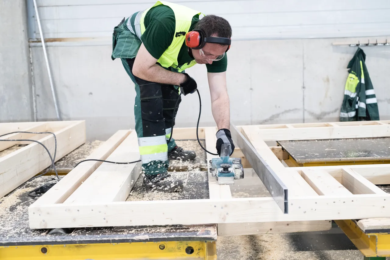 Man planing wooden elements