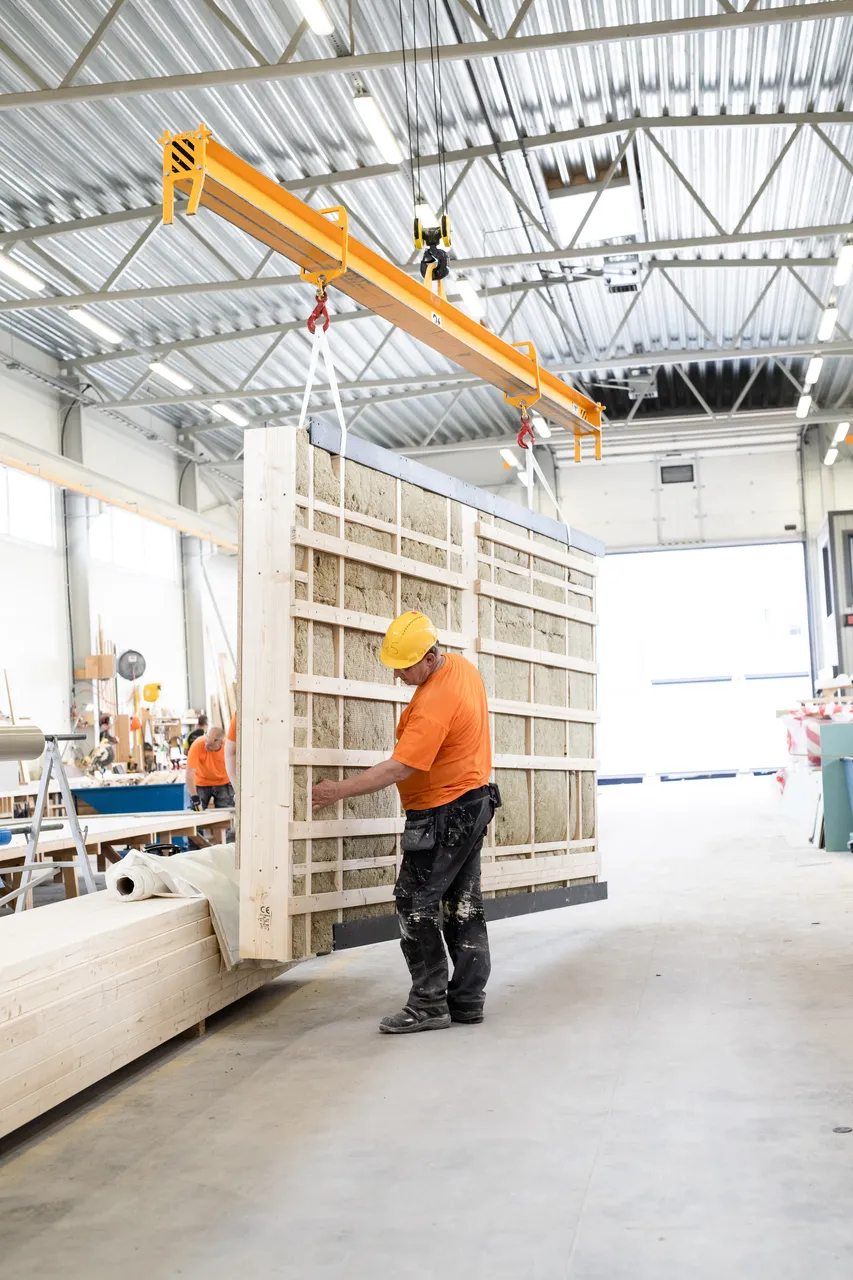Man lifting wooden modular house elements