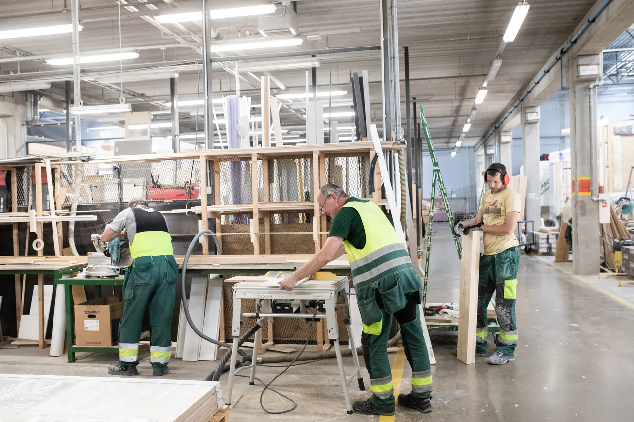 Men working at wooden modular house factory