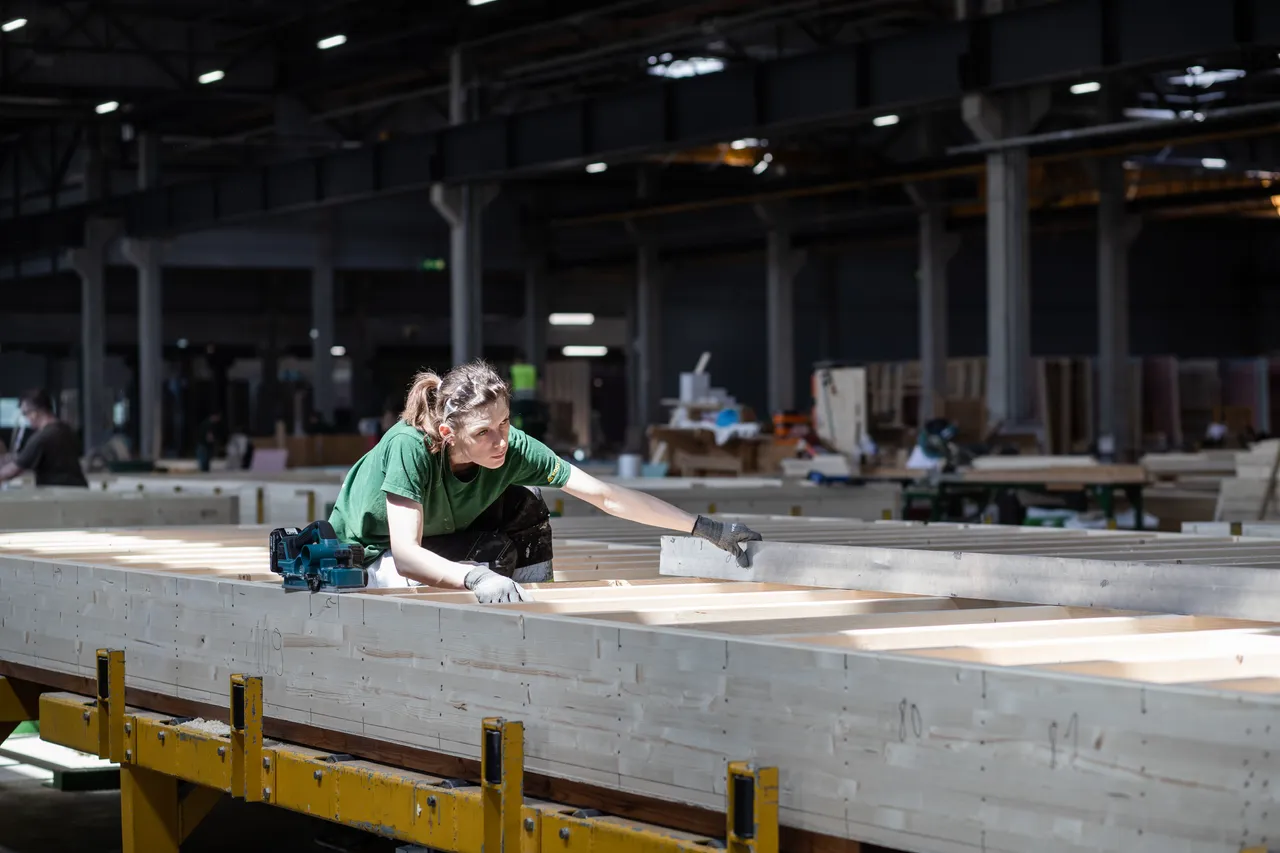 Woman building wooden modular house elements