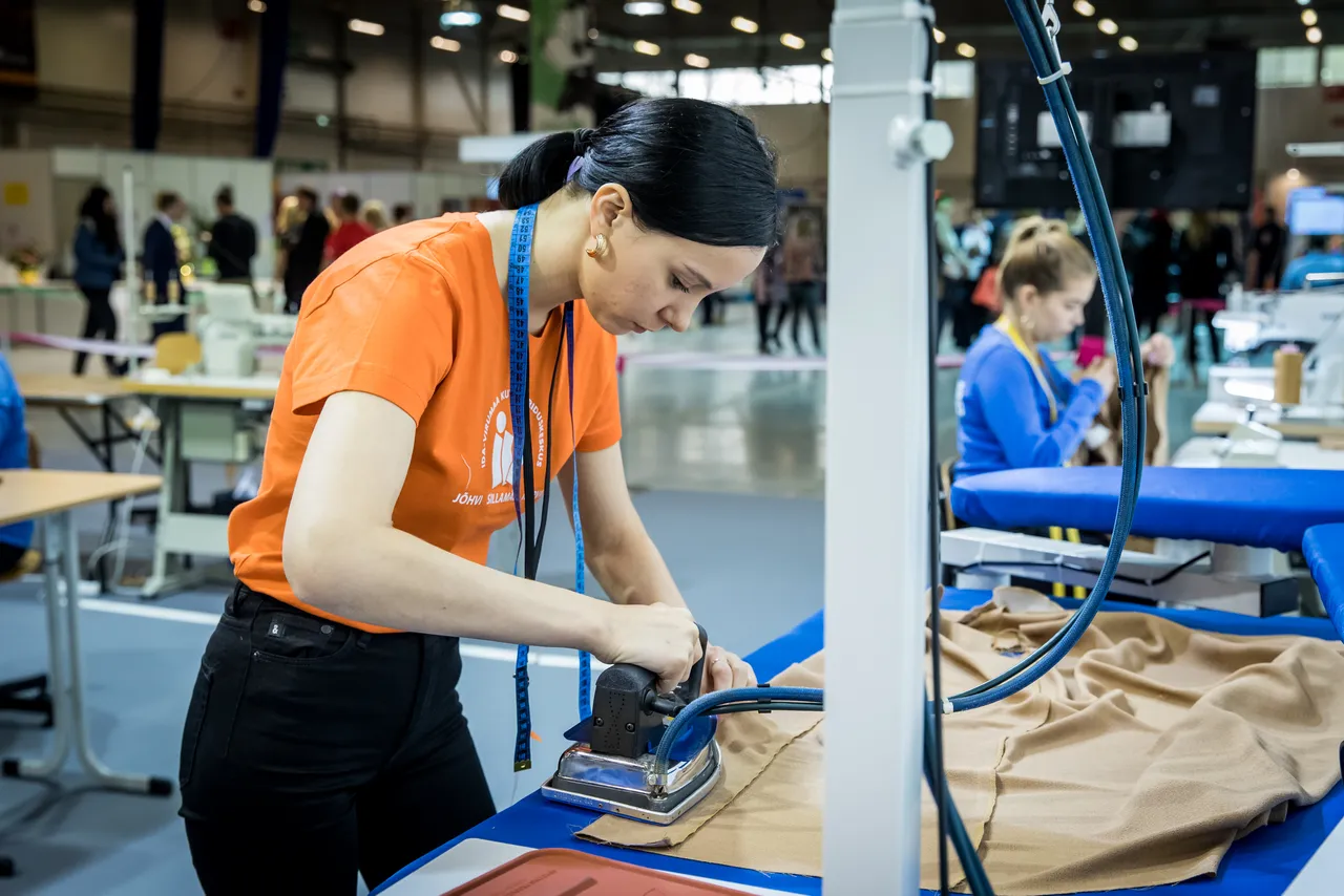 Young tailor student ironing