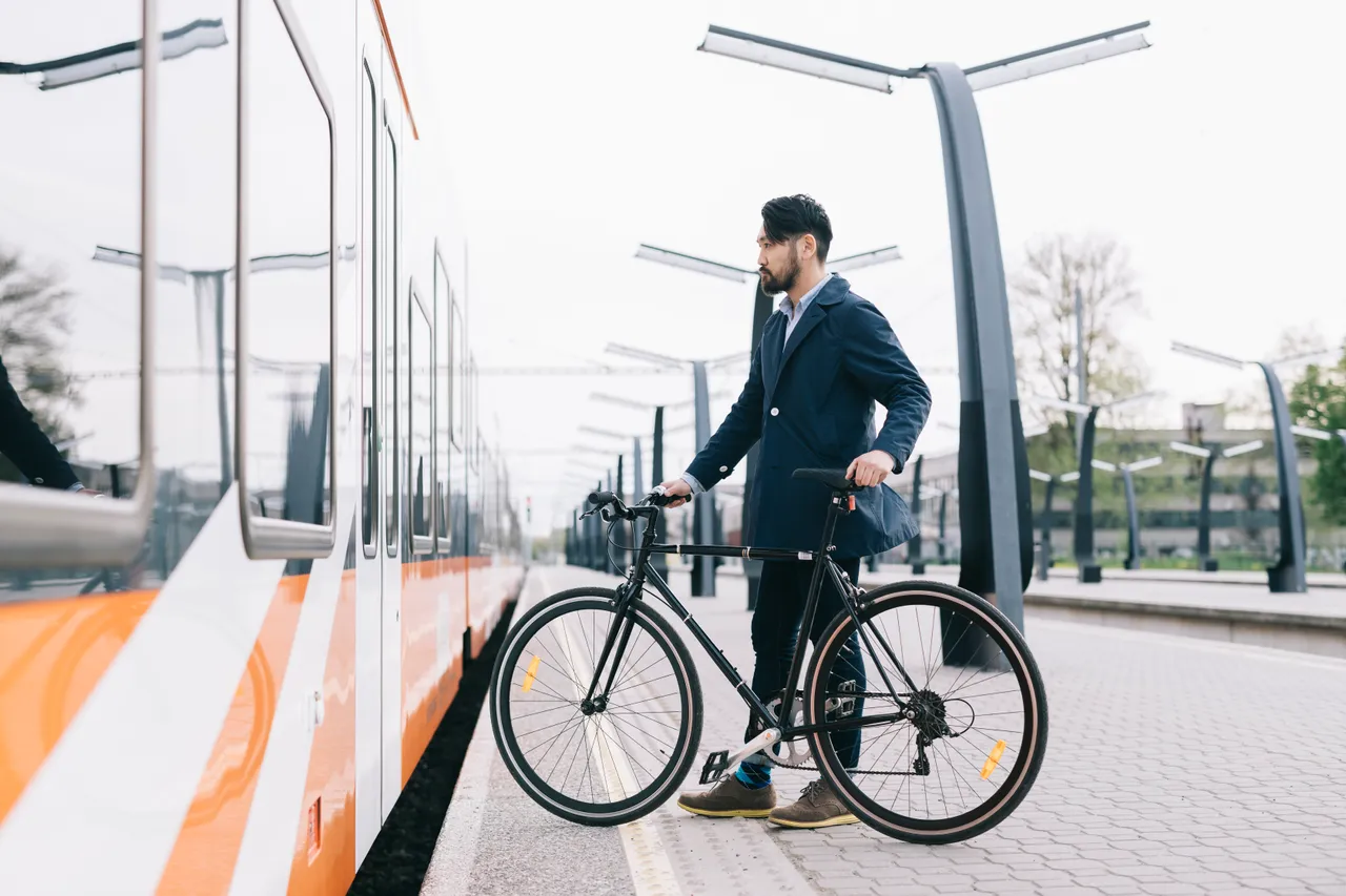 Man getting on train with bike