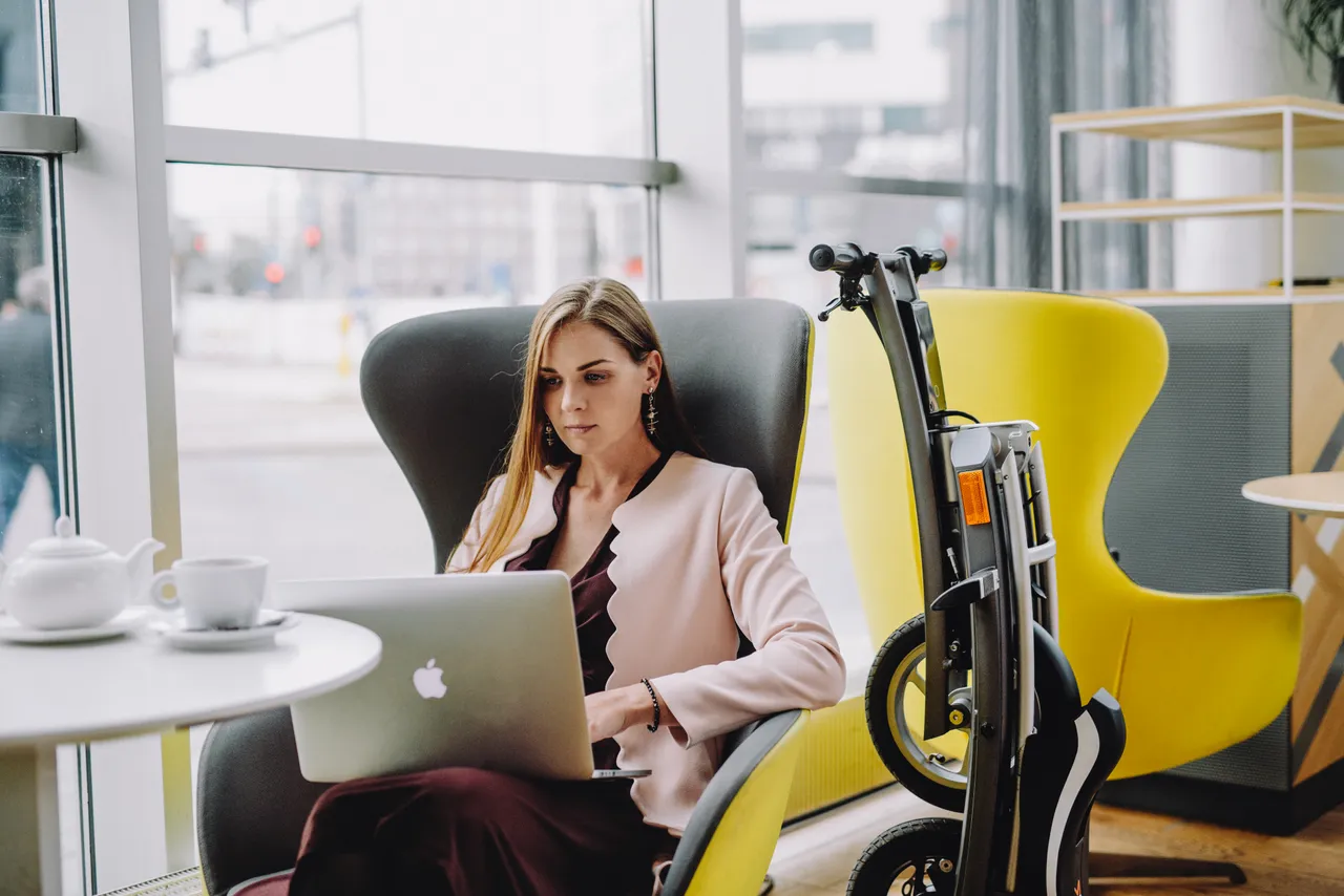 Woman in a cafe with laptop and bike