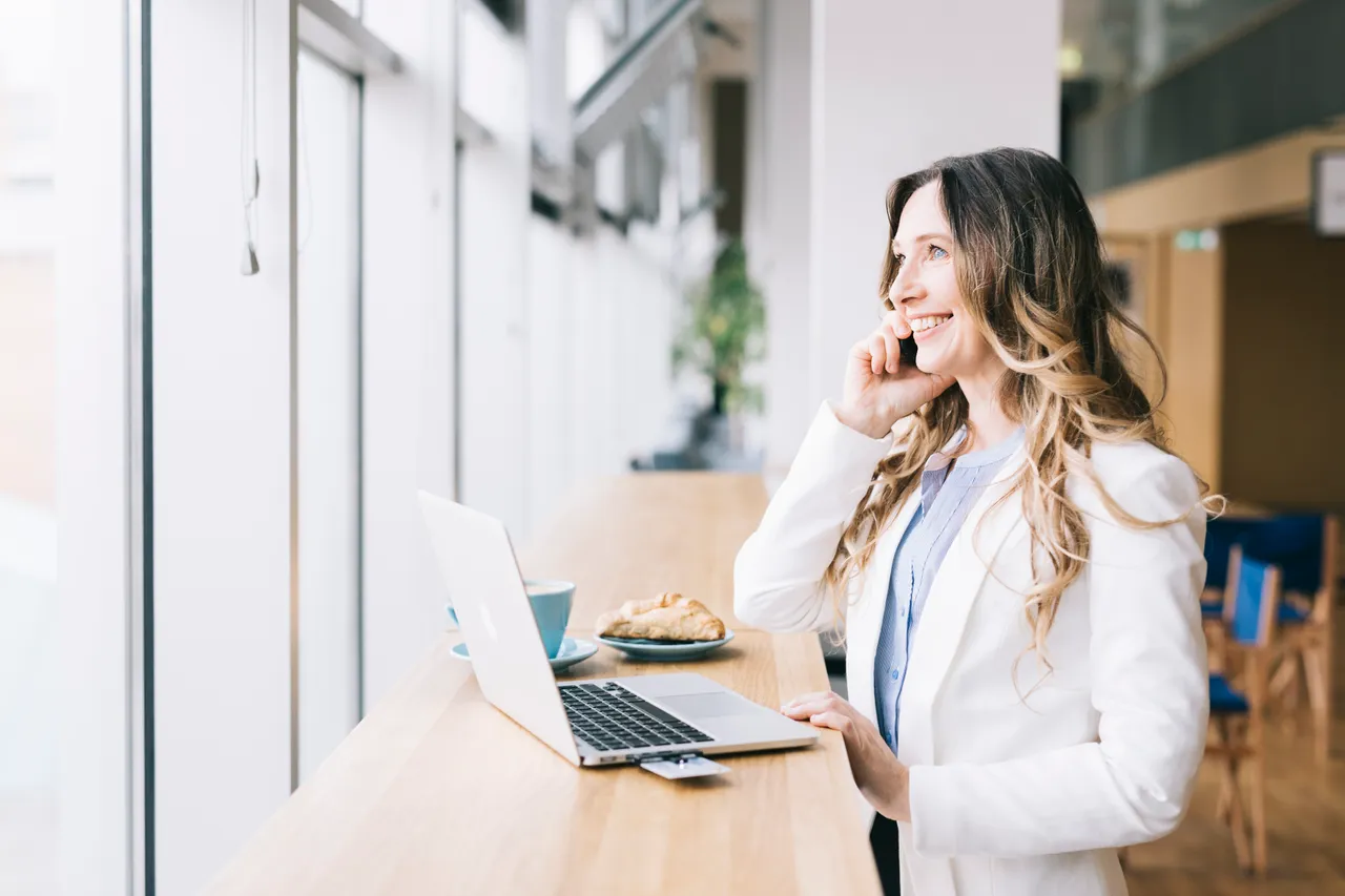 Woman calling and working on a laptop