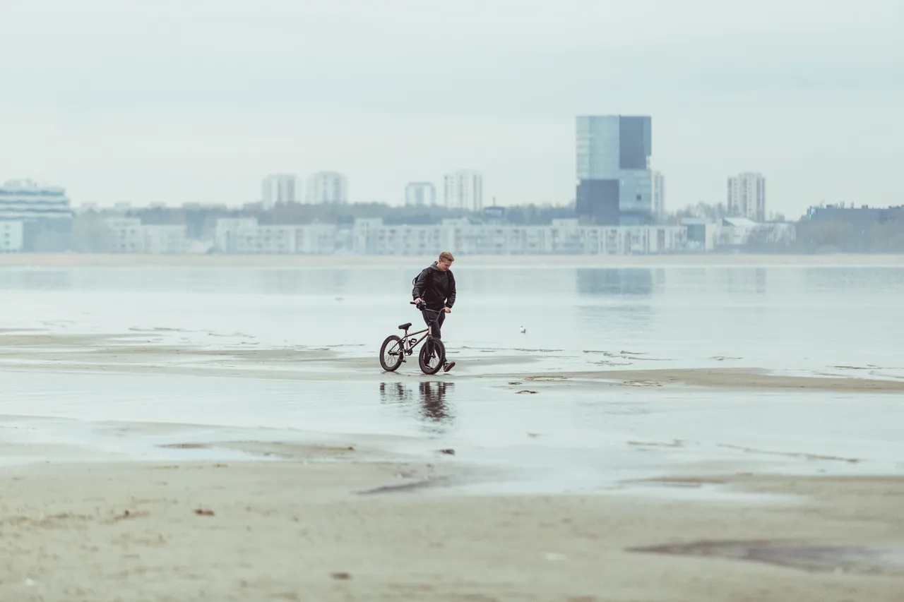 Cyclist Walking by the Stroomi Beach Side