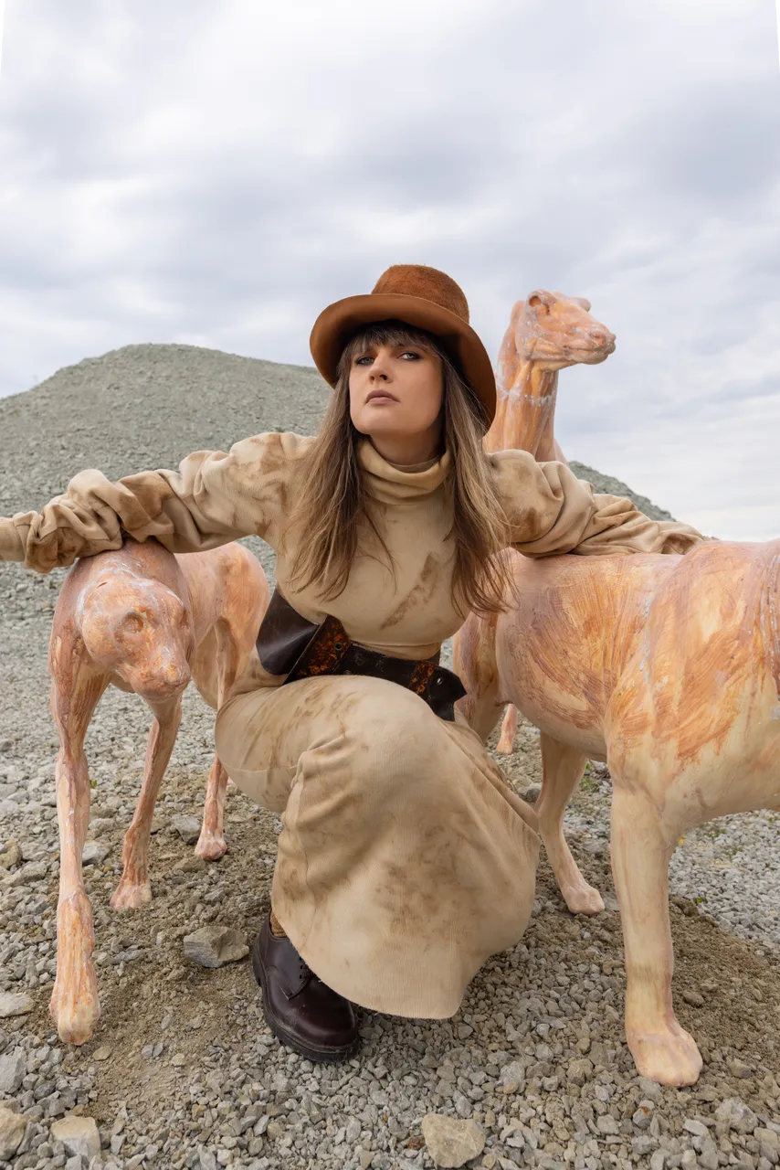 Edith Karlson with her animal sculptures in an outdoor setting.