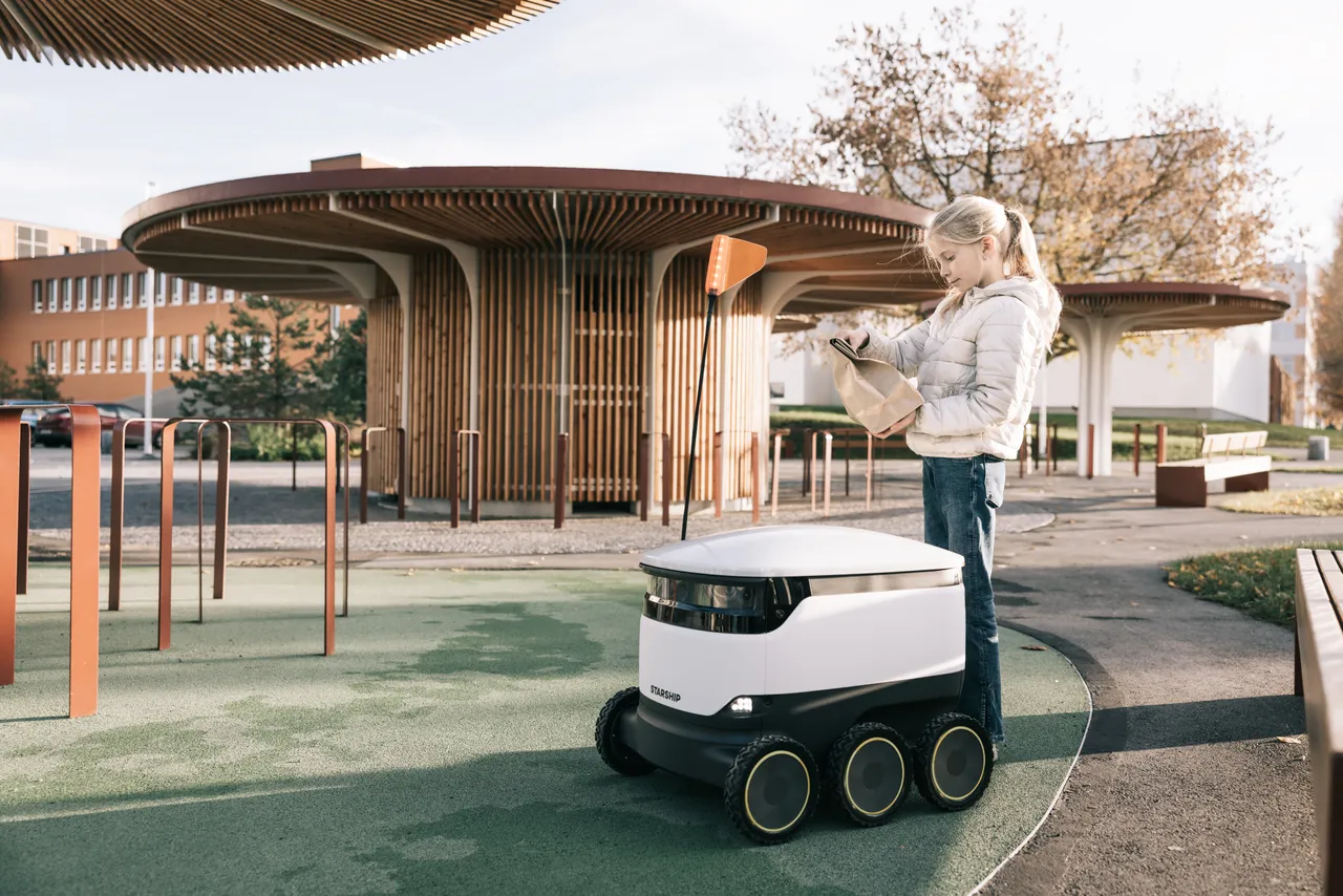 Girl receiving package from Starship robot