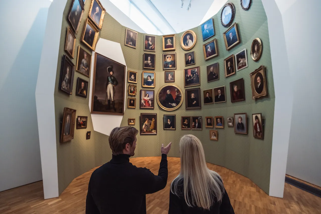 Couple viewing portrait wall in museum