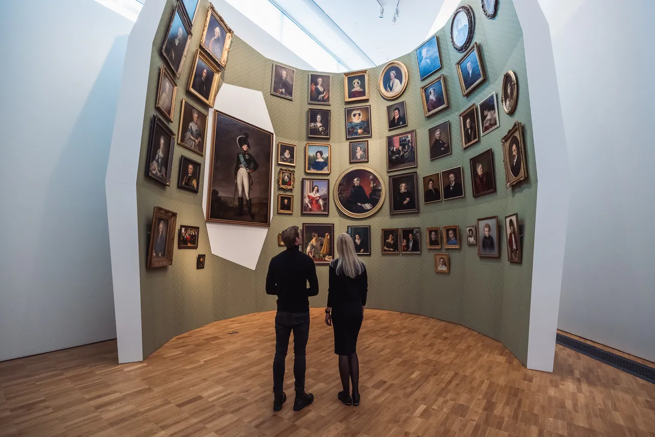 Couple viewing portrait wall in museum