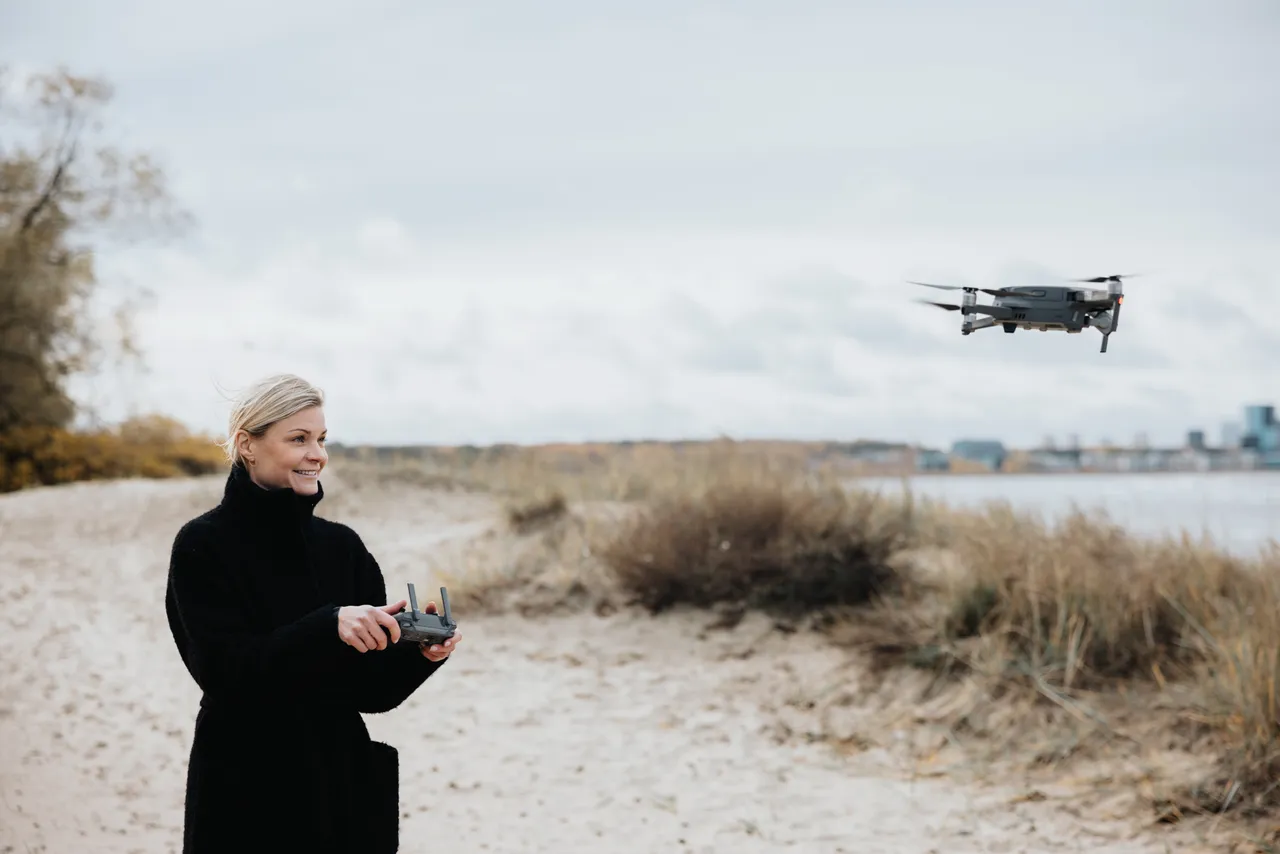 Woman flying a drone on the beach