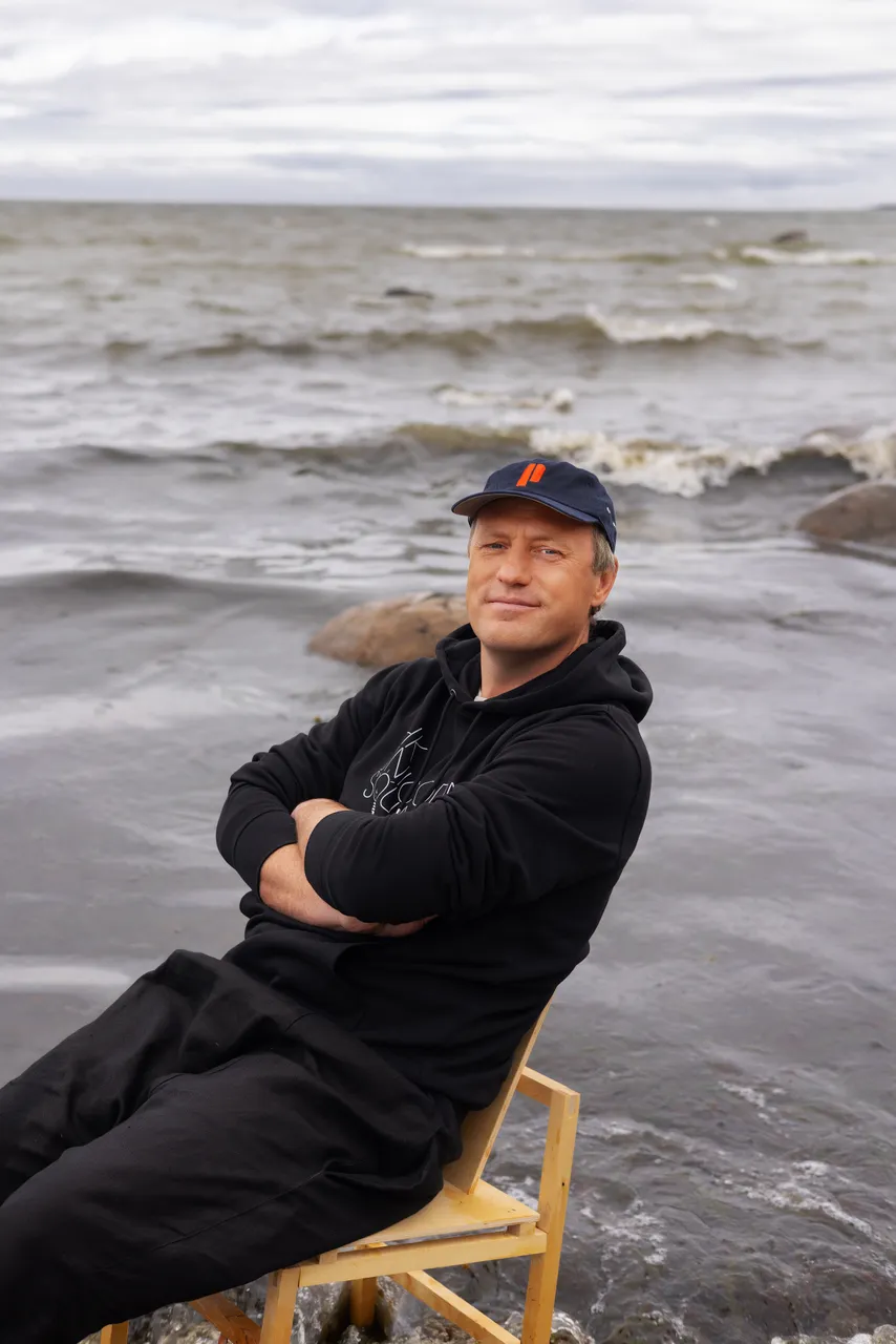 Taavi Kotka, Estonian entrepreneur and digital society pioneer, sitting barefoot on a chair in the sea.
