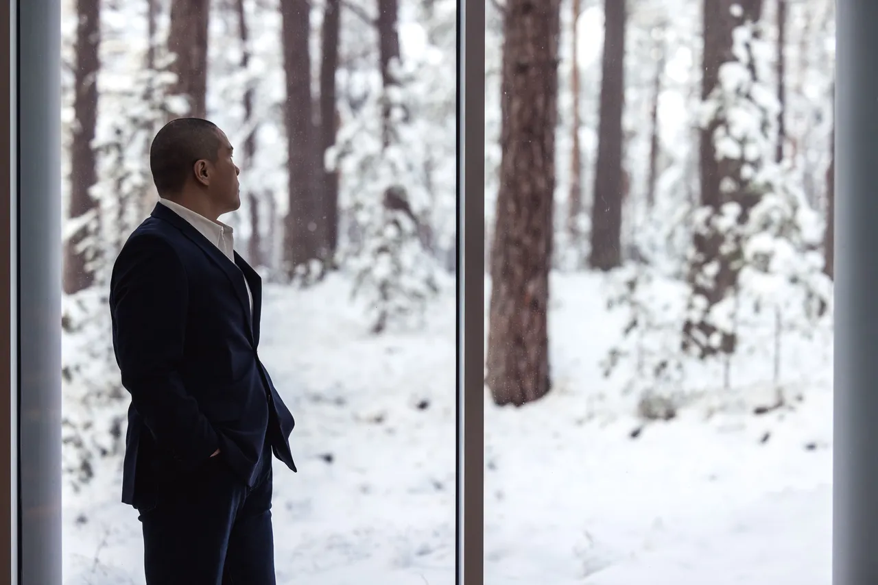 Man Looking Out at Snowy Forest