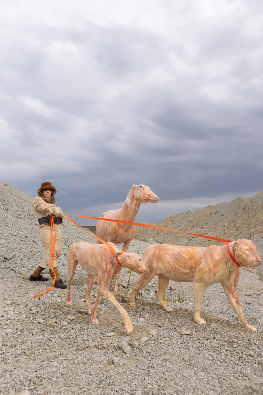 Edith Karlson with her animal sculptures in an outdoor setting.