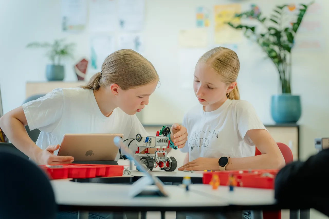 Two girls building a robot