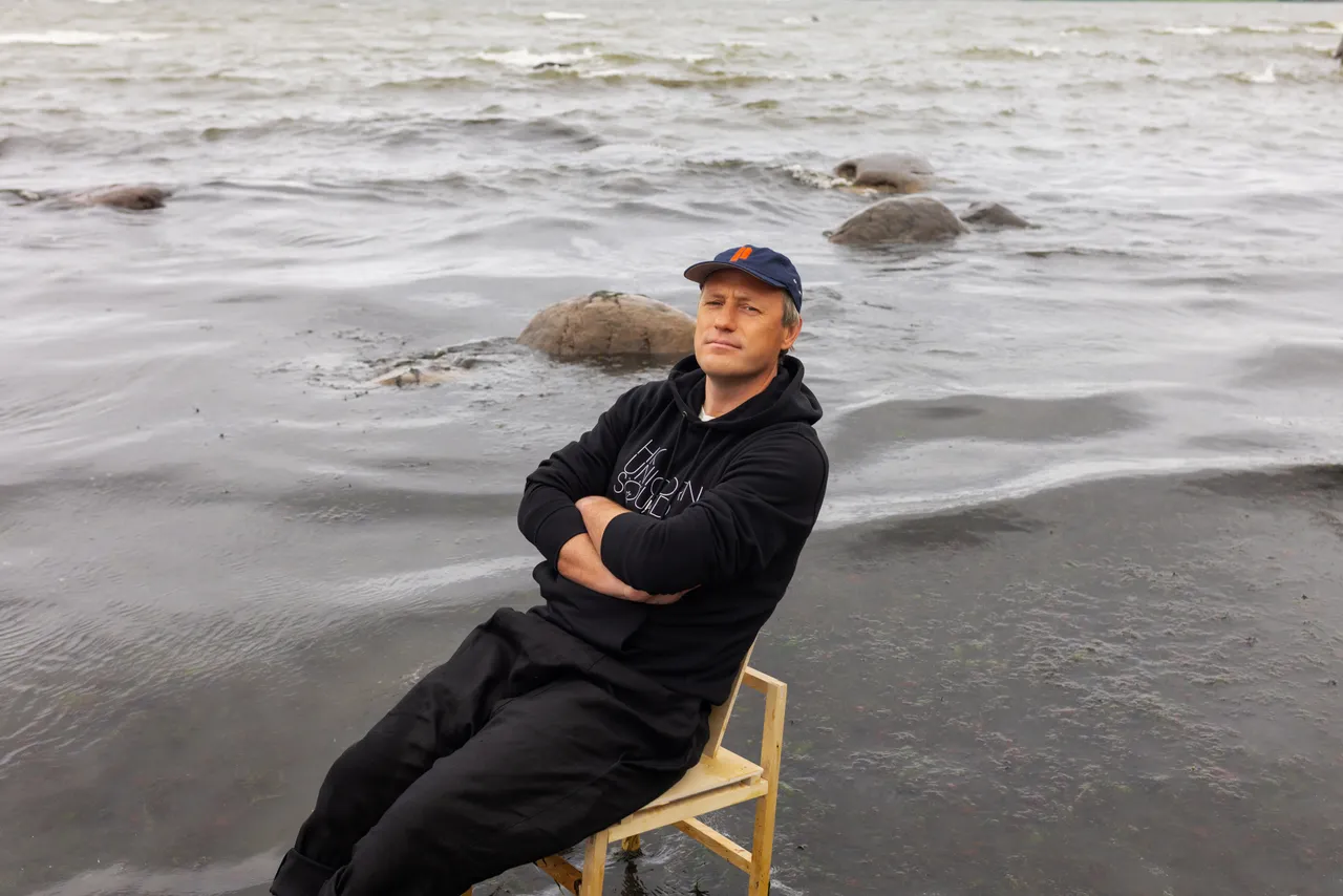 Taavi Kotka, Estonian entrepreneur and digital society pioneer, sitting barefoot on a chair in the sea.