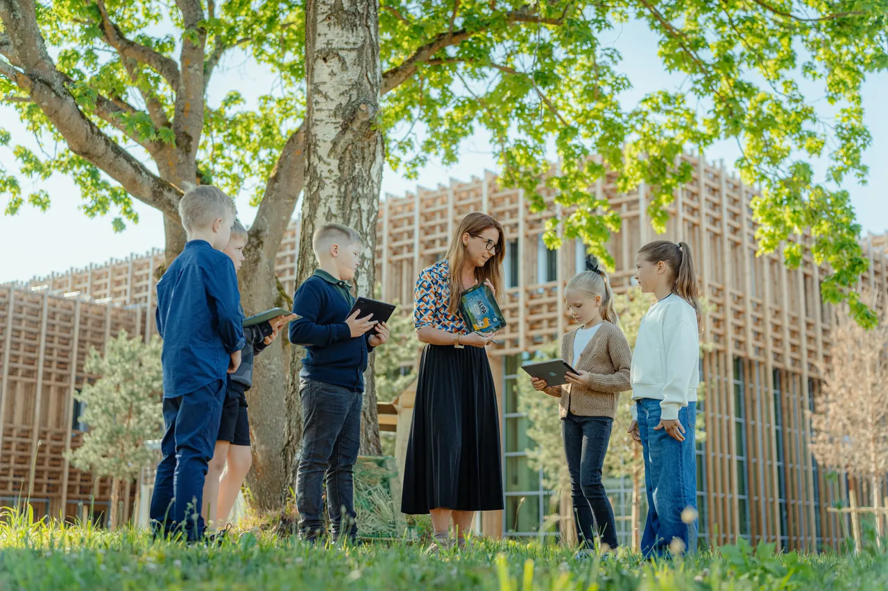 Teacher and students using tablets outdoors