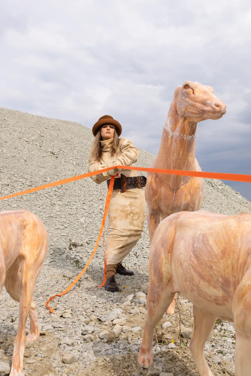 Edith Karlson with her animal sculptures in an outdoor setting.