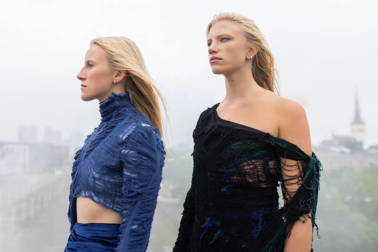 Two women from Duo Ruut, Katariina Kivi and Ann-Lisett Rebane, playing kannel outdoors in a misty urban setting.