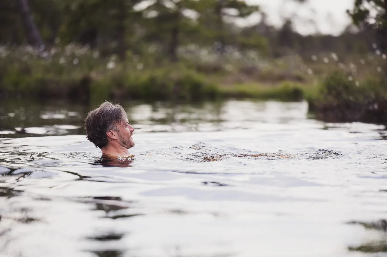Man swimming in bog lake