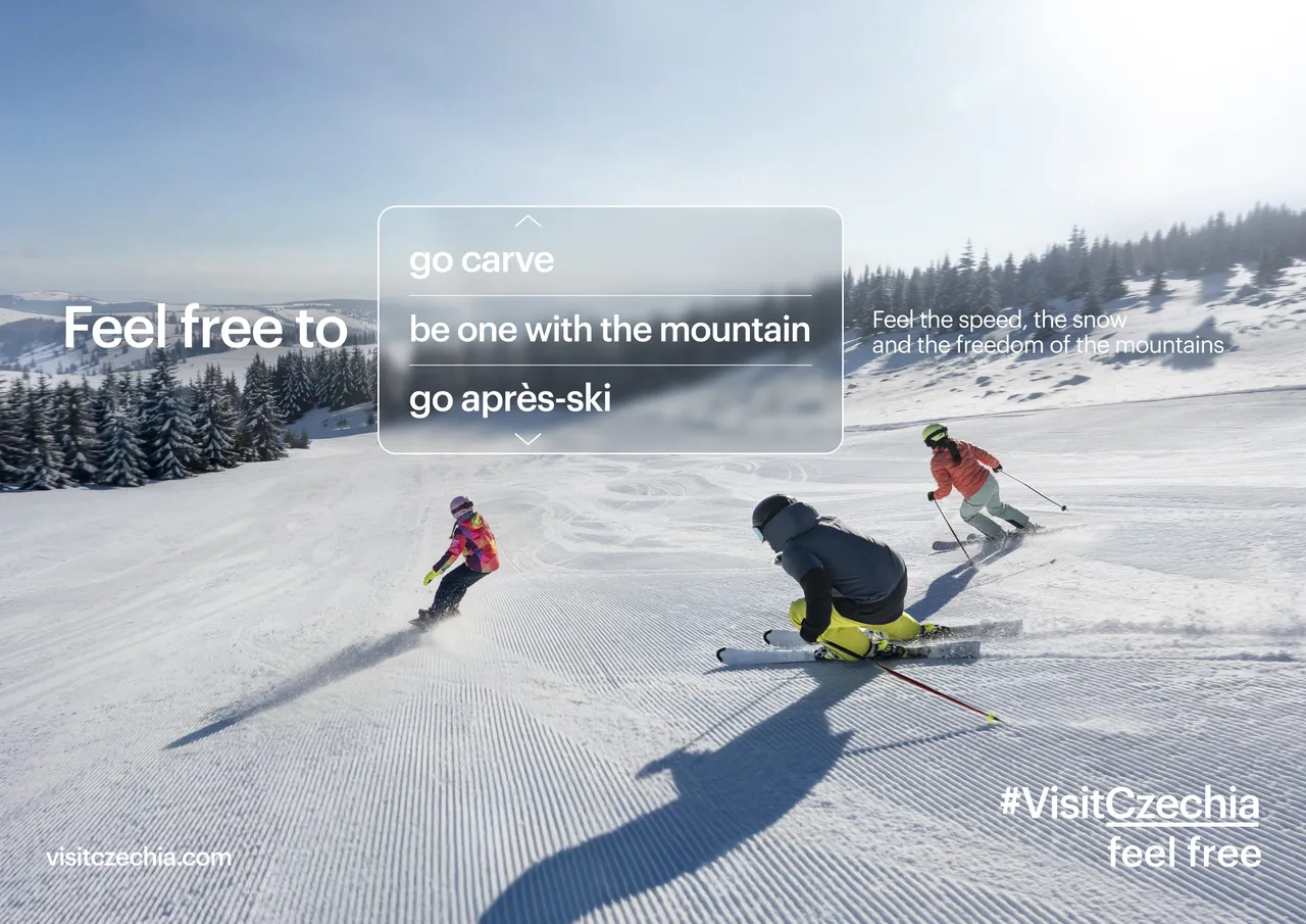 Three skiers carve down a groomed snowy mountain slope beneath a clear blue sky.