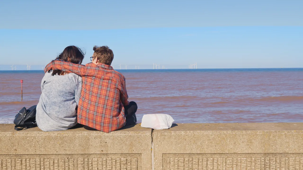 A couple embrace overlooking the windfarms off the Yorkshire coast©Project Yorkshire 2022
