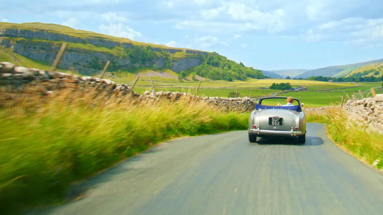 A classic Aston Martin is driven through the heart of the Yorkshire Dales